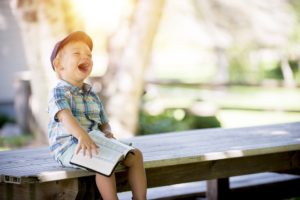 Boy laughing with a book